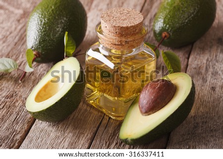 Vitamin avocado oil in a glass bottle on a wooden table close-up, horizontal