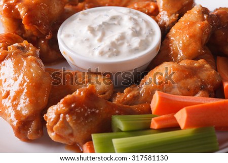 American fast food: buffalo wings with sauce on a plate macro. horizontal