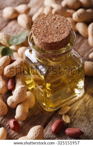 Natural peanut oil in a glass jar macro on the table. vertical