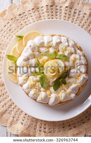 Beautiful lemon meringue cake close up on the table. vertical top view