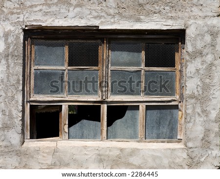 Aged window with broken glasses and wire mesh