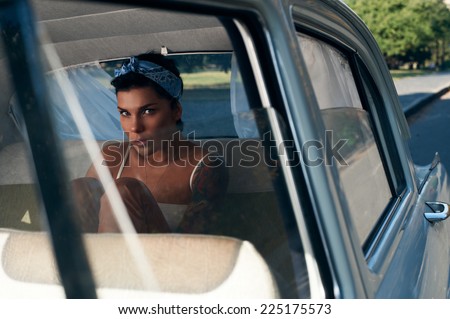 pin-up lady with tattoos in retro car