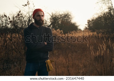 lumberjack in apple orchard standing in the rays of the autumn sun