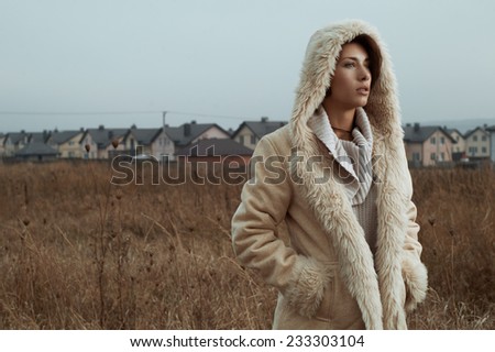 woman standing in fields behind country town