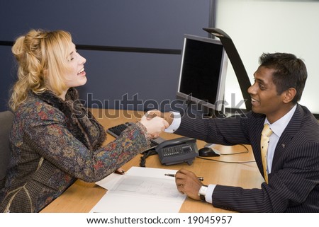Indian Business Man and Caucasian Woman Handshaking on a Deal