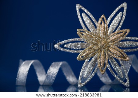 Christmas holiday snowflake and silver ribbon on dark blue background