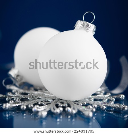 White and silver christmas ornaments on dark blue background with space for text. Merry christmas card. Winter holidays. Xmas theme.