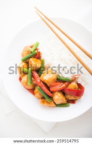 Spicy chicken with vegetables ( green beans and red pepper) and rice top view. Oriental food.
