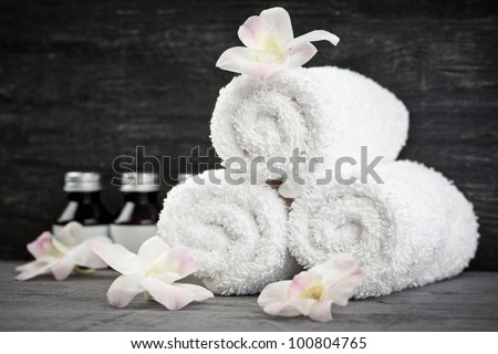 White rolled up towels with body care products at spa