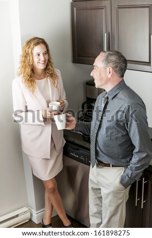 Man and woman having conversation in office coffee break area