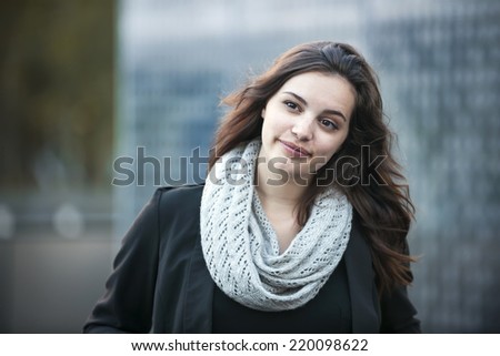 Candid portrait of young brunette woman looking away outside with copy space