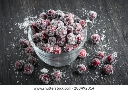 Sugared cranberries holiday dessert in bowl on rustic wooden background