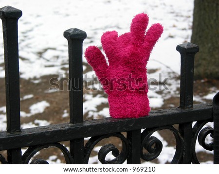 Lost child\'s glove on wrought iron fence in winter time