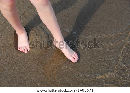 Girl testing water on a beach