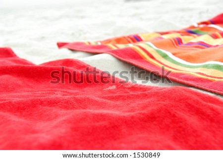 Two colorful beach towels on sandy beach