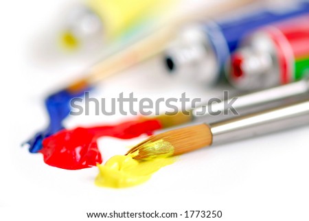 Macro of paintbrushes and paint tubes of primary colors