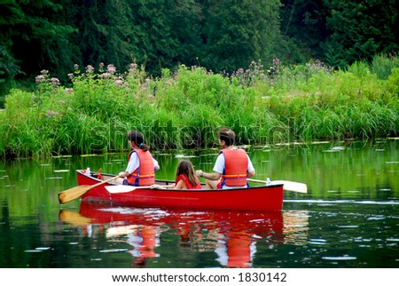 Family of three canoing on a calm river