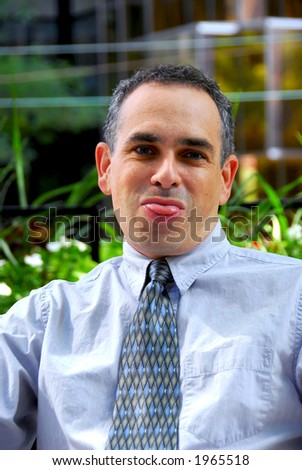 Businessman making a silly face sticking his tongue out