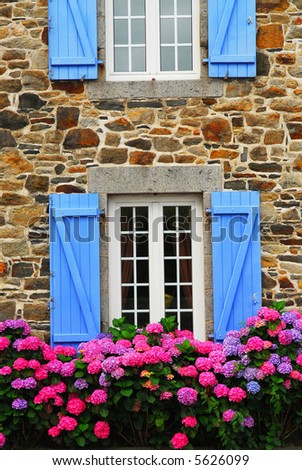 Fragment of a typical country house with blue shutters in Brittany, France