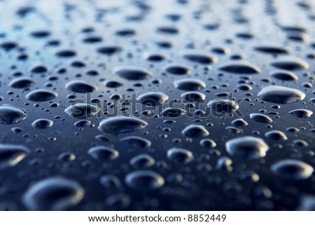 Abstract background of water drops on a blue metal surface