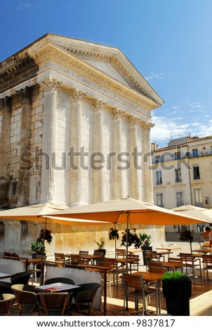 Roman temple Maison Carree and outdoor cafe in city of Nimes in southern France