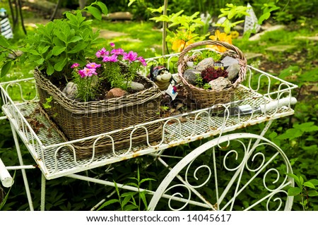 Flower cart with two baskets in summer garden