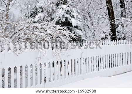 Fence in winter park covered with fresh snow
