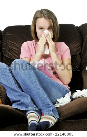 Teenage girl with a cold sitting in a chair with tissue box