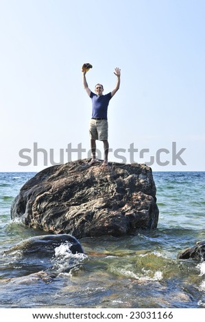 Man stranded on a rock in ocean calling for help