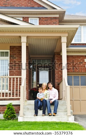 Young family sitting on front steps of house