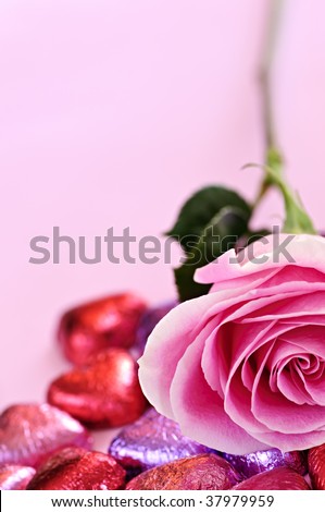 Pink rose with Valentine\'s chocolates wrapped in red and purple foil