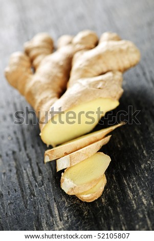 Close up of sliced fresh ginger root spice on wooden table