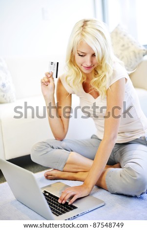 Happy blonde woman internet shopping online at home