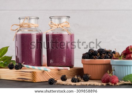 Fresh red fruits smoothie on vintage decorated  wooden table.