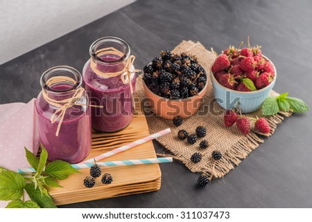 Fresh red fruits smoothie on vintage decorated  wooden table.