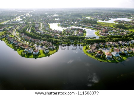 backlit aerial view of luxury florida suburban residential community around lakes
