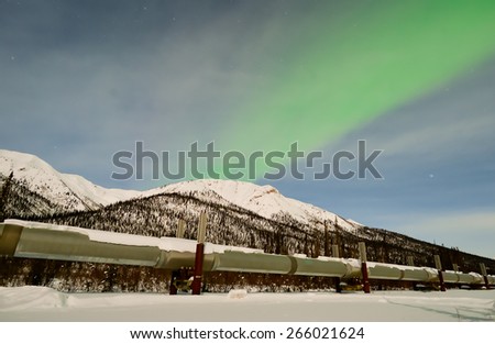 DALTON HWY, ALASKA-MARCH 2, 2015:  Alaska\'s North Slope oil pipeline carried 7% less crude oil in Jan. 2015 vs prior year and 70% less than Jan. 1985.  Pipeline seen under an aurora on Mar. 2, 2015.