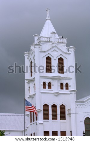 st paul episcopal church is landmark on duval street in old town of key west florida, seen with american flag against stormy clouded sky