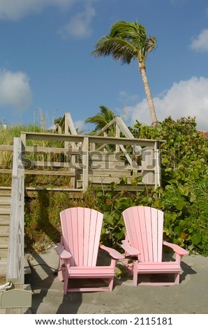 pair of pink adirondack beach chairs along atlantic ocean in florida