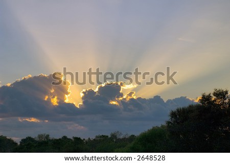 god rays from behind clouds at sunrise