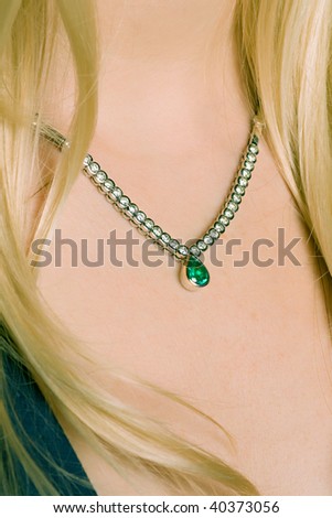 lovely blond female model neckline with emerald diamond necklace