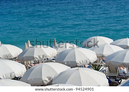white umbrellas on the rivierra beach at nice france