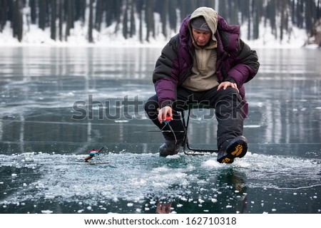 Ice fisherman on winter mountain lake