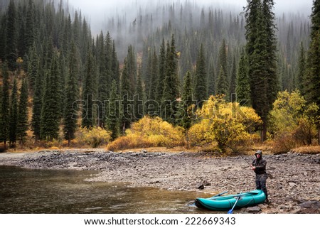 Autumn fishing under rain on the lake Kolsai, Kazakhstan