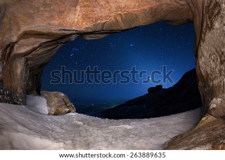 The cave and night sky in winter desert mountains Bektau-Ata, Kazakhstan.\
NOTE: Low resolution because the night shot with high ISO.