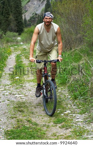 Mountain biker on old rural road in spring mountain