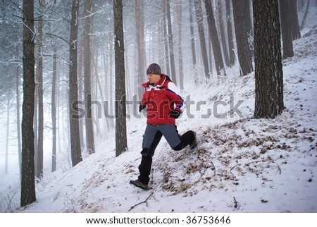 Blurred motion of running man in winter mountain forest