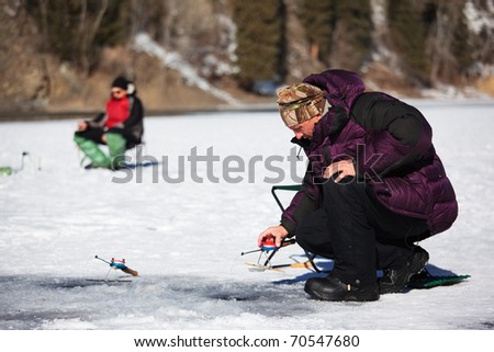 Ice fisherman on winter lake
