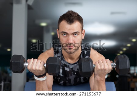 man lifts dumbbells