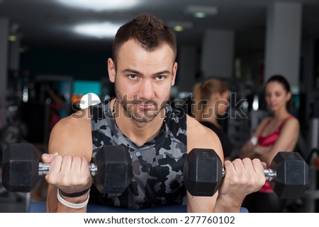 man lifts dumbbells